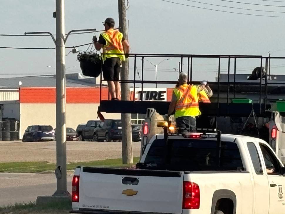 Flower baskets going up in Steinbach, a sign that summer is here